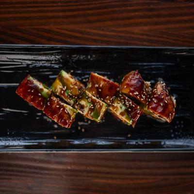 Sushi rolls topped with avocado and BBQ eel sauce.