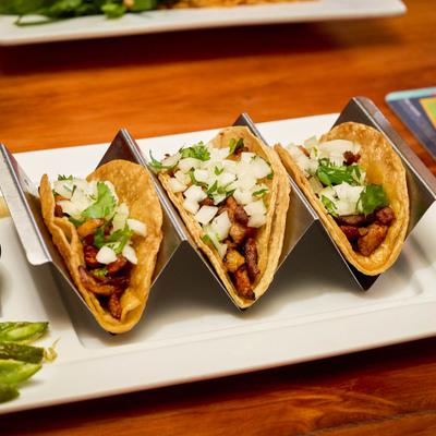 Tacos al pastor topped with onion and cilantro.