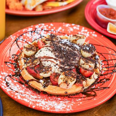 waffle with chocolate drizzle, bananas and strawberries.