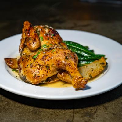 Roast chicken served with green beans and roasted potatoes.