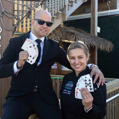 Two staffers posing with cards in their hands.