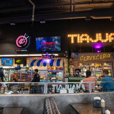 Tijuana Food Court with booth seating and neon signs.