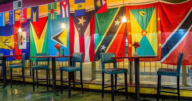 Interior, bar tables and stools, flags hanging on windows