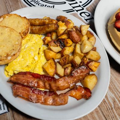Bacon, scrambled eggs, potatoes, toast, and sausages.
