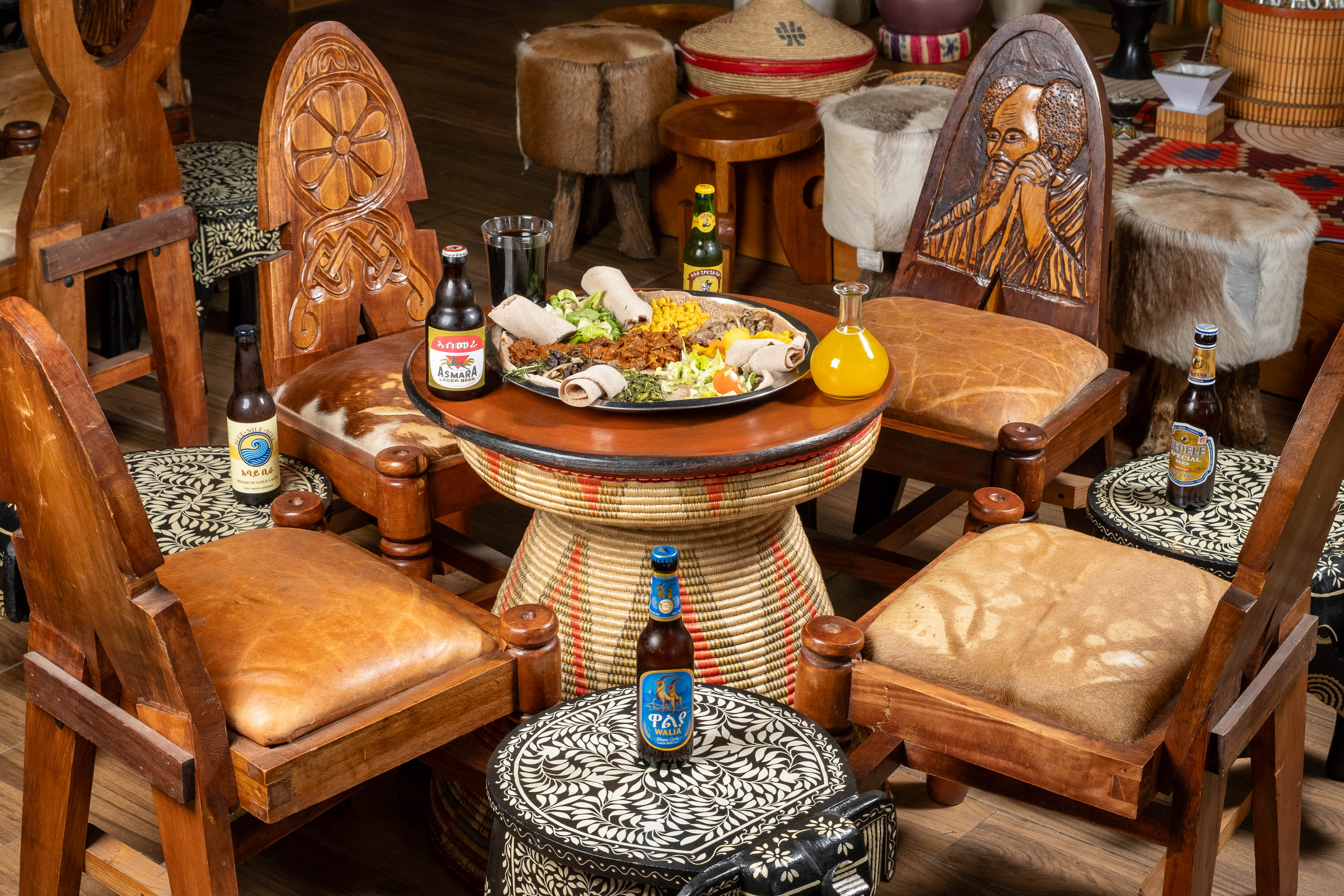 Dining table with Ethiopian food and drinks surrounded by chairs