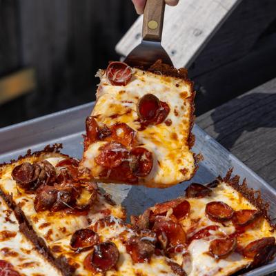 Pepperoni pizza slice lifted from the pie.