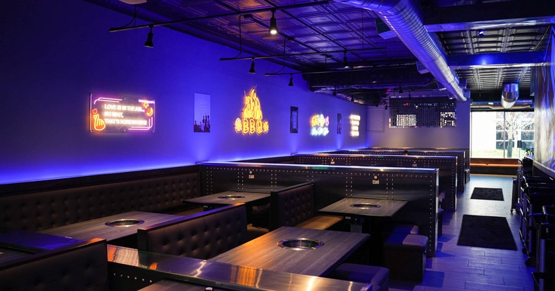 Interior, booths with tables and grills, neon signs on the wall