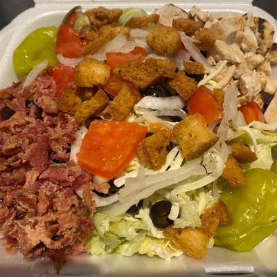Grilled chicken salad, with bacon, lettuce, tomato, pepperoncini, olives, and croutons.