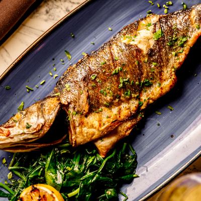 Whole branzino served with spinadh and grilled lemon.