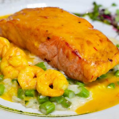 Salmon filet in a creamy saffron sauce with shrimp served with asparagus risotto.
