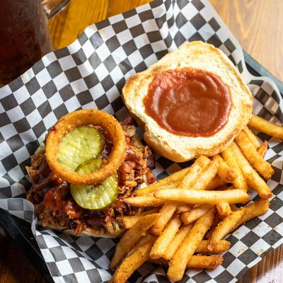 BBQ Pulled Pork Sandwich with pickles, fried onions, and fries.