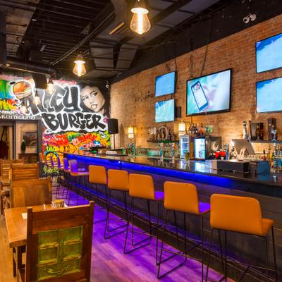 Interior, bar counter and chairs, tv's on the wall above drink rack