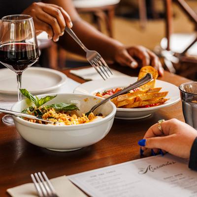 Two patrons enjoying meals and drinks at a table.