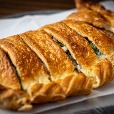 Calzone with a sliced pastry crust, close-up.