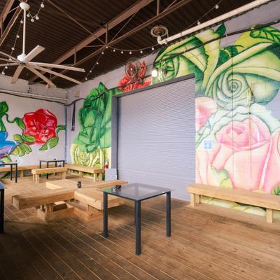 Interior featuring a vibrant mural of large roses and a seating area.