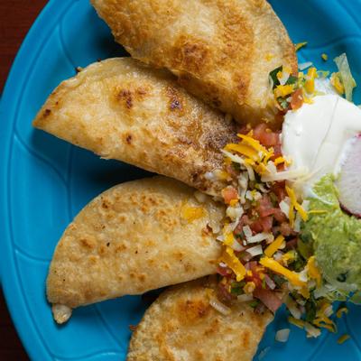 Cripsy quesadillas filled with Manchengo cheese,  sour cream and fresh-made guacamole