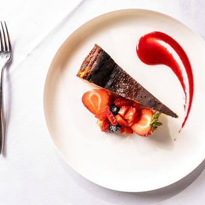 Cheesecake slice, with strawberries on the side.