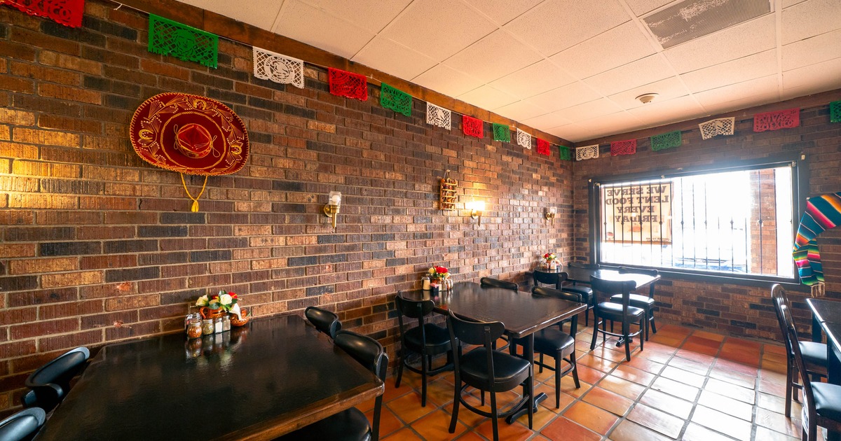 Interior, tables with chairs near the brick wall