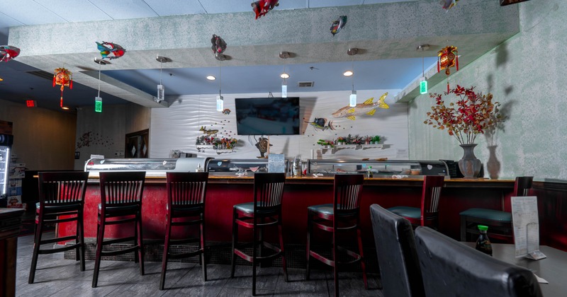 Interior of a sushi restaurant with a counter, high-backed chairs