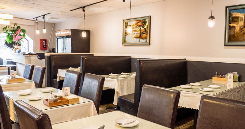 Cozy interior dining area with upholstered dining booths and tables set for guests