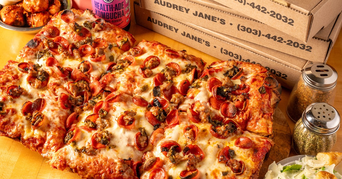 Thick, rectangular Detroit-style pepperoni pizza served next to cardboard boxes
