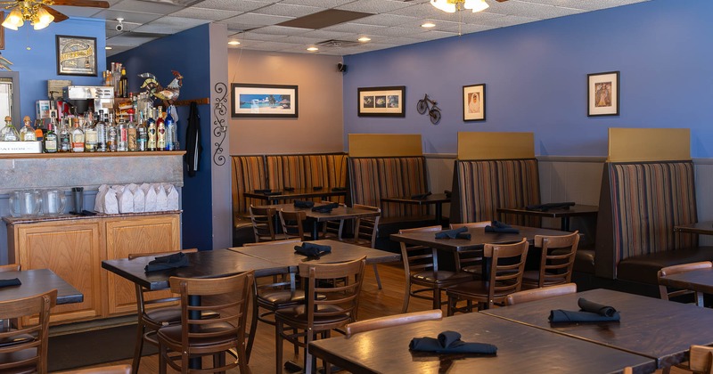 Interior, dining area with tables and dining booths with paintings on the wall