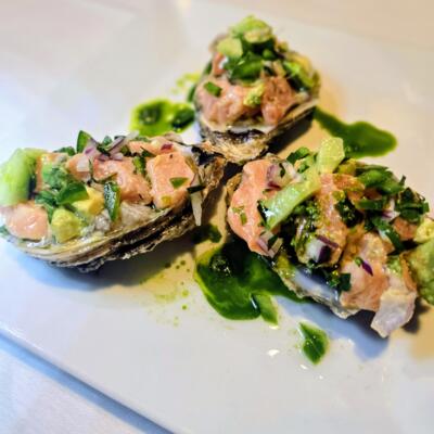 Raw Oyster and Salmon with avocado, onion, cucumber, jalapenos with a olive oil and parsley.
