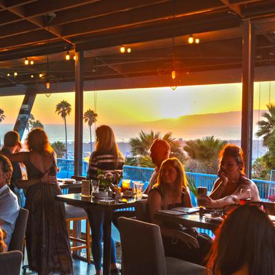 This is a scene of The Lobster from the bar, at sunset, with people having a good time..