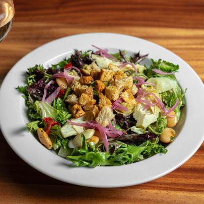 A fresh salad - greens, artichoke hearts, white beans, pickled onions, roasted peppers, croutons