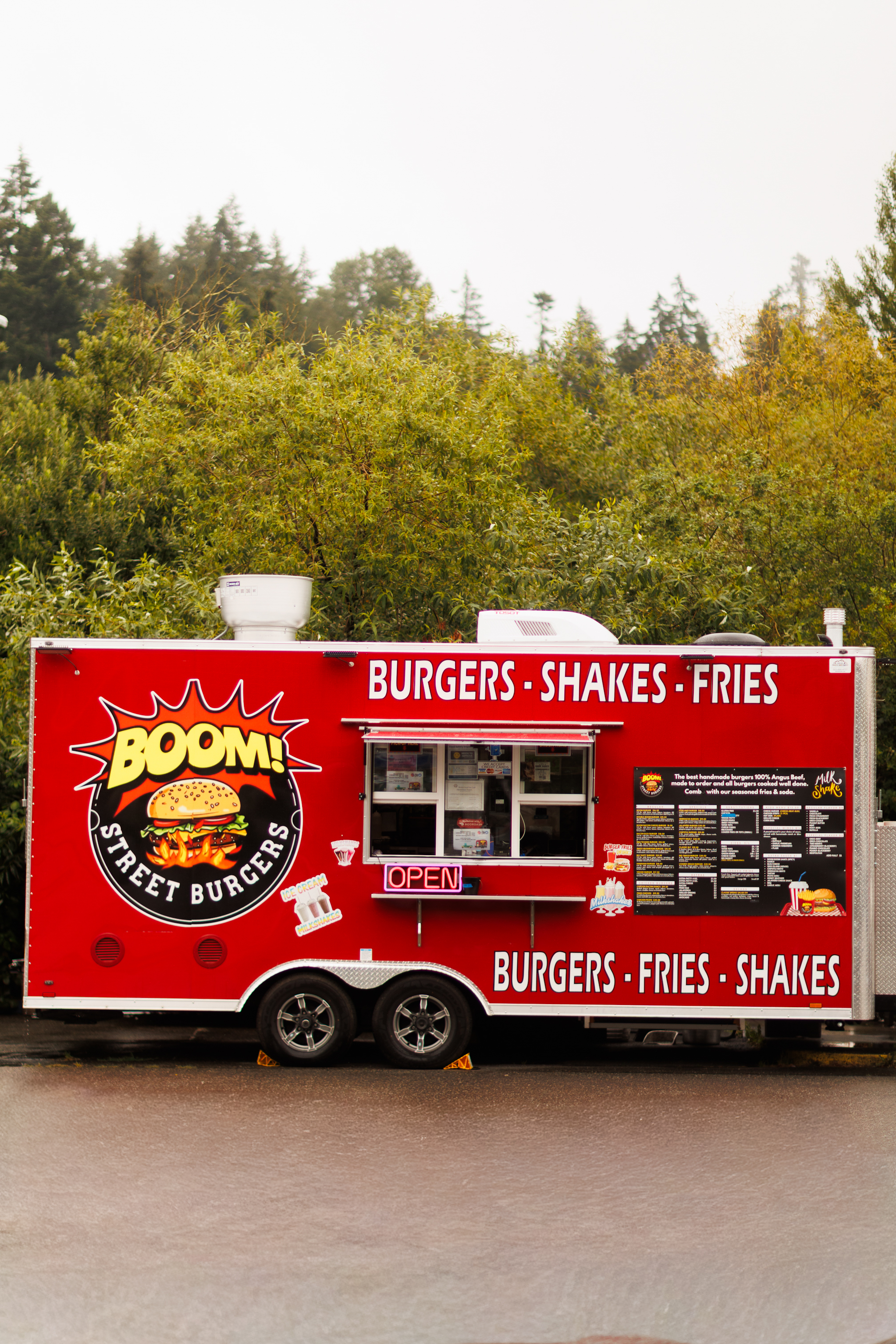 Red food truck featuring signage, a menu board and a service window