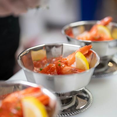 Multiple shrimp cocktails served in a decorative metal bowls, close-up.