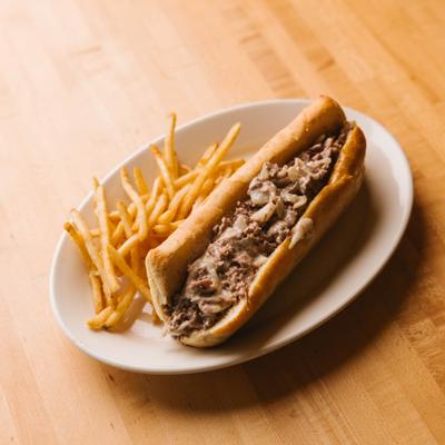 Philly cheesesteak paired with French fries.