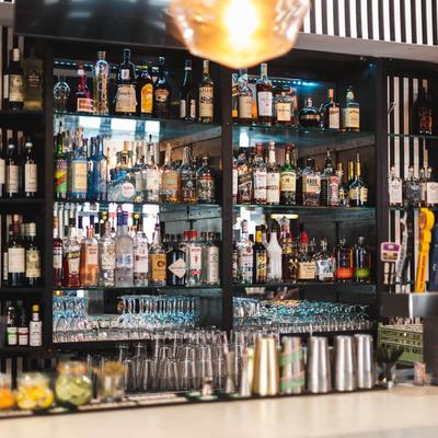 Bar area, bottles and glasses on the shelf.