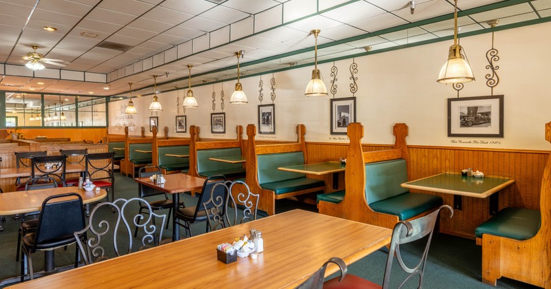 Interior, open space dining area, tables for four and two, row of booths with tables