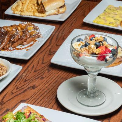 A variety of breakfast or brunch dishes served on a wooden table.