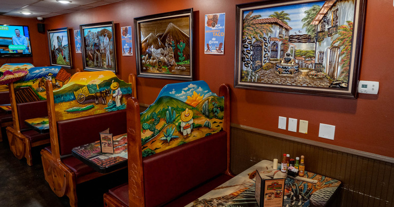 Restaurant booths with vivid paintings on the wall and backrests
