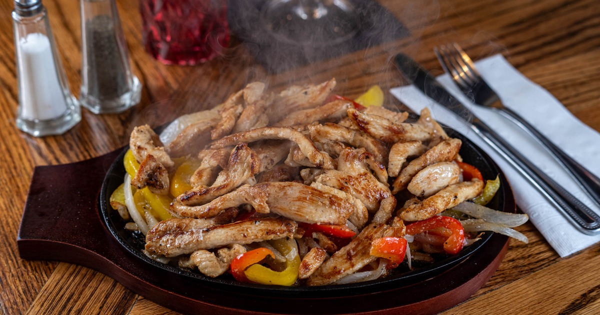 Sizzling chicken fajitas served on the restaurant table