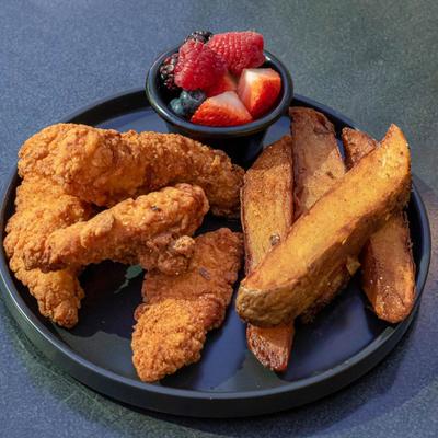 Chicken tenders served with potato wedges and fresh berries.