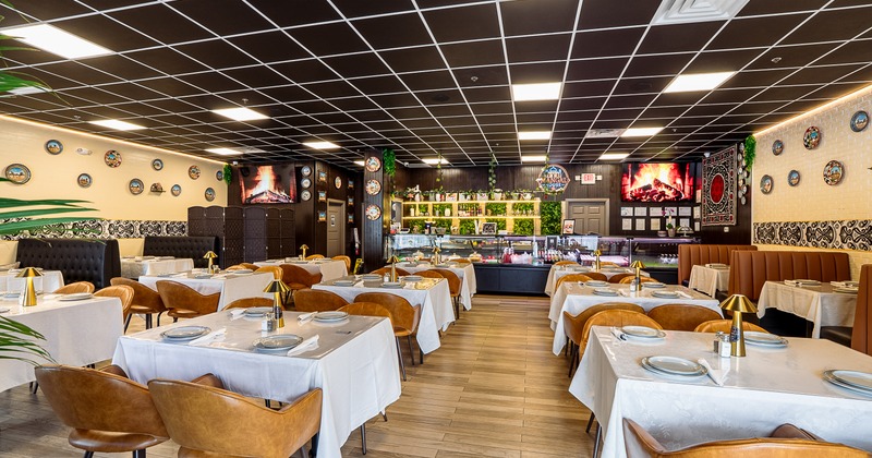 Modern, elegant and spacious interior dining area with set dining tables and brown leather chairs