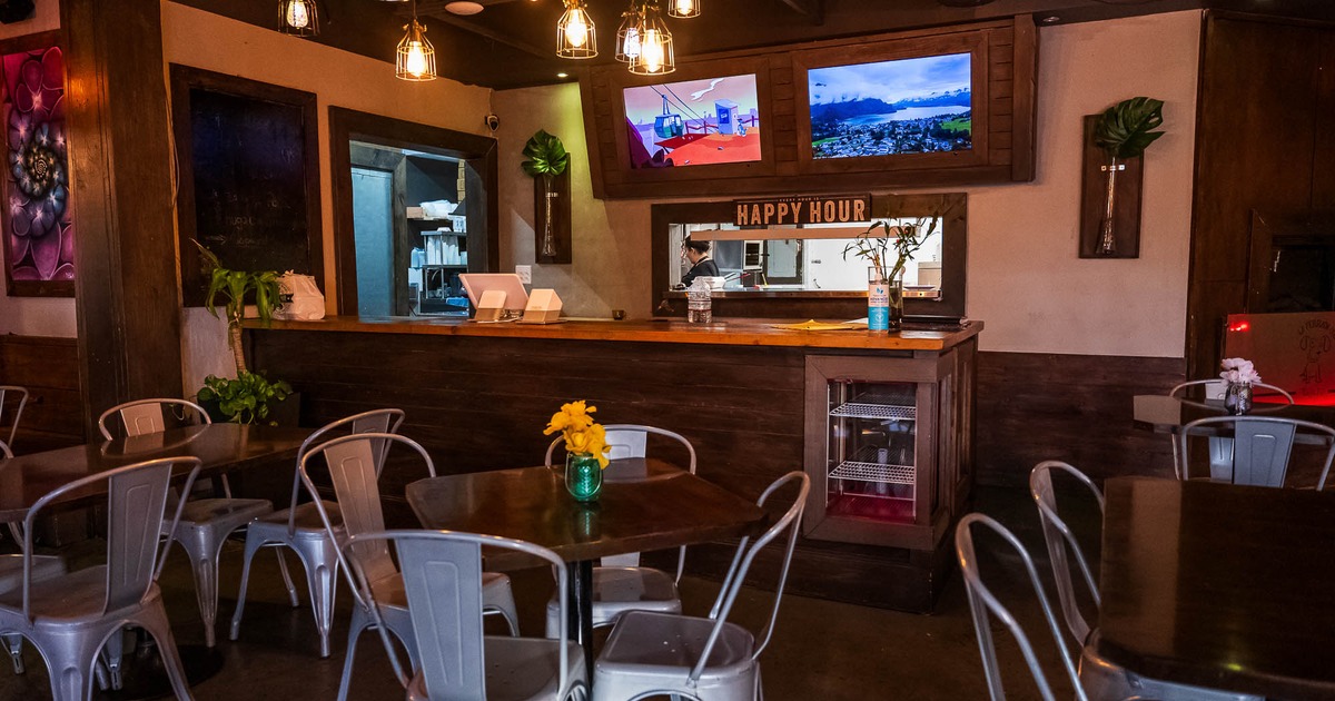 Interior, tables and chairs with bar behind them