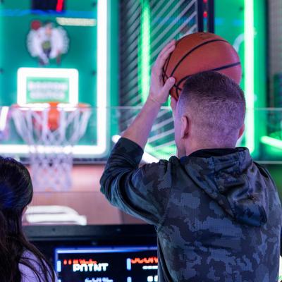 A person playing the arcade basketball game.