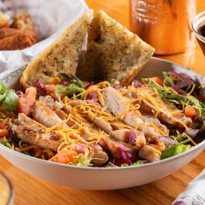 Southwest Chicken Salad topped with grated cheese and served with garlic bread.