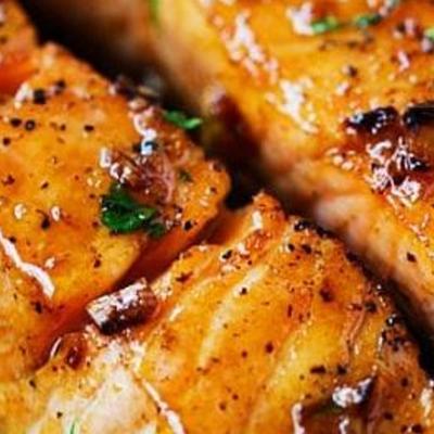 Seared salmon topped with herbs and seasoning, close-up