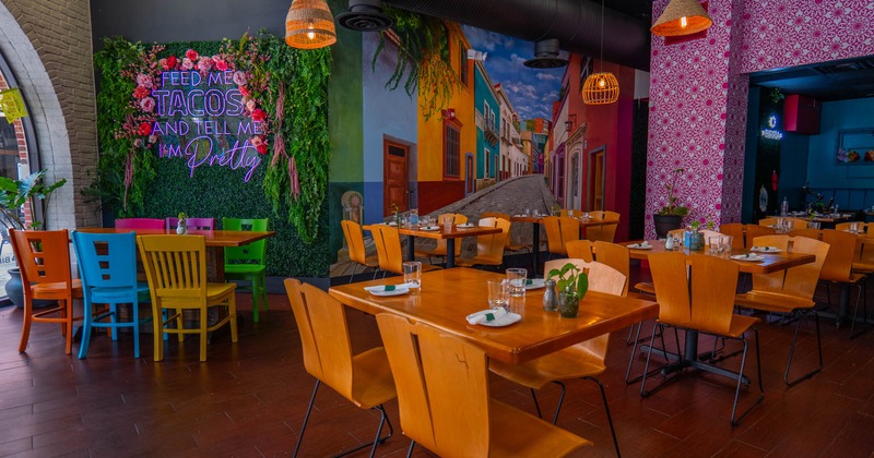 Interior, dining area, tables for four and six, large Mexico inspired mural of a town