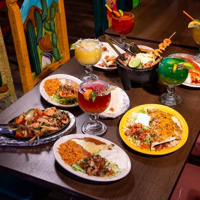 A vibrant spread of Mexican dishes and colorful margaritas.
