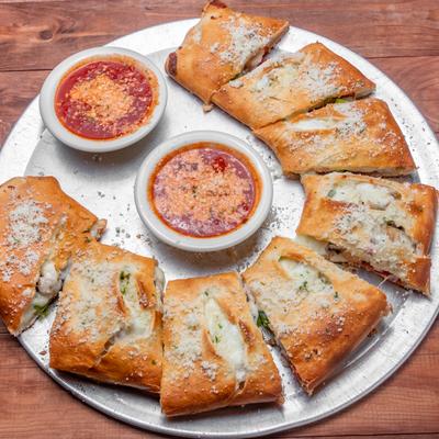Calzone with tomato based sauce on the side.