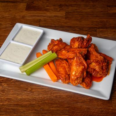 Wings coated in a spicy sauce served with celery, carrots, and ranch dip.