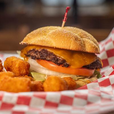 Cheeseburger served with tataer tots, close-up.