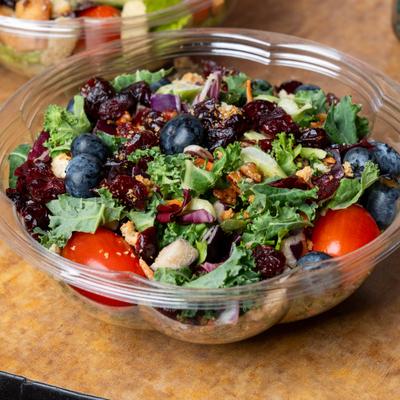 Salad with greens, blueberries, cranberries, nuts, and tomato.