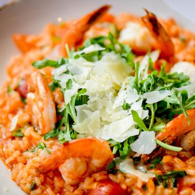 Pan seared shrimp over risotto with arugula and cherry tomatoes